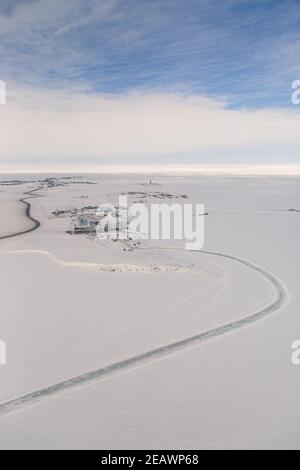 Aerial view of industrial area of arctic hamlet Tuktoyaktuk in winter surrounded by frozen Arctic Ocean, Northwest Territories, Canada. Stock Photo