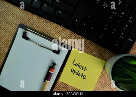 Latest Update write on sticky notes isolated on Wooden Table. Stock Photo