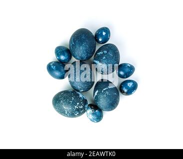 A group of chicken and quail eggs with a marble-blue color on a white background. Stock Photo
