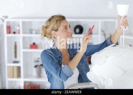woman installing new ceiling light in her home Stock Photo