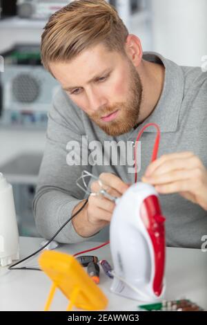 young male technician checking appliance Stock Photo