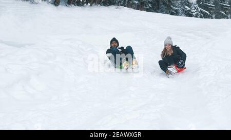 Happy young multiracial couple sliding on snow. Winter sports. High quality photo Stock Photo
