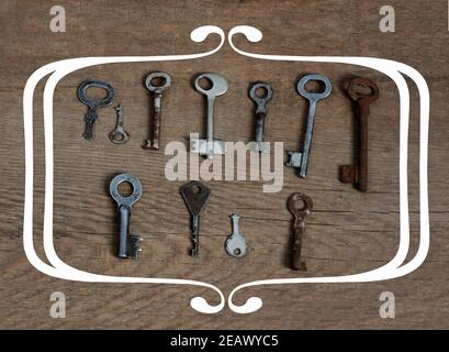 Old fashioned keys on wooden aged background with frame concept for text Stock Photo