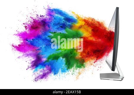 modern black silver pc computer monitor with colorful rainbow spray holi powder cloud explosion through flat screen isolated on white background. mult Stock Photo