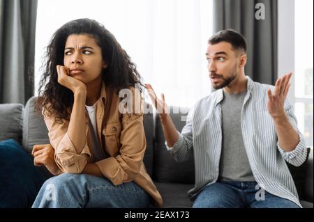 Married young couple emotional discuss about something, they having problem. African american woman and caucasian man disagree with each other have a Stock Photo