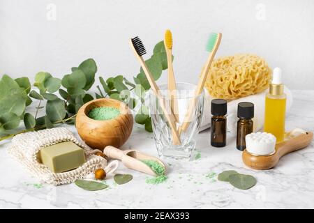 Eco-friendly bathroom accessories: bamboo toothbrush, sea sponge, natural soap in organic saver bag and eucalyptus oil and bath salt. Zero waste spa a Stock Photo