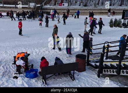 Skaters on the world's longest rink changing into or out of their skates. Rideau Canal, Ottawa, Ontario, Canada. Stock Photo