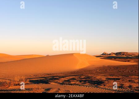 sunset in the desert near Sur (Oman) with a large sand dune Stock Photo