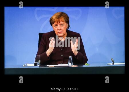 Berlin, Germany. 10th Feb, 2021. Photo taken in Berlin, Germany, on Feb. 10, 2021 shows a screen displaying German Chancellor Angela Merkel attending a press conference after a video conference with federal state leaders. Germany will extend lockdown efforts to contain the COVID-19 pandemic for three more weeks till March 7, Merkel and the 16 federal state leaders decided on Wednesday. Credit: Shan Yuqi/Xinhua/Alamy Live News