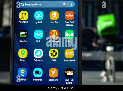 Ireland. 10th Feb, 2021. In this photo illustration the Orderow, goPuff, Just Eat, Door Dash, Uber Eats, Wolt, McDelivery, Bolt, Glovo, Deliveroo, EASI, Jumia Food, Lidl Plus, Deliveries, Lalamove and Grub Hub logos are seen displayed on a mobile phone screen with an image of a food delivery courier displayed on a computer screen. Credit: Cezary Kowalski/SOPA Images/ZUMA Wire/Alamy Live News Stock Photo