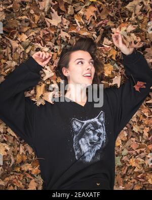 girl lying in and playing with leaves Stock Photo