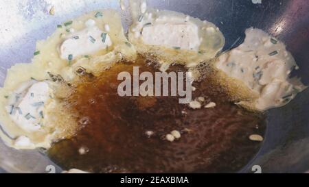 Cooking or frying tempeh in hot oil. Tempeh or tempe is a traditional Indonesian soy product. Stock Photo