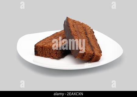 Pieces of cake on a white plate. Close-up. Isolated on white background. Stock Photo