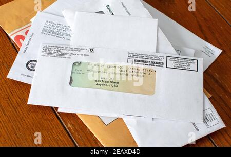Stimulus check is shown on top of a stack of mail. the check is in the mail. Stock Photo