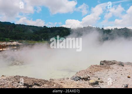 Sikidang crater with the background of sulfur vapor coming out of the sulfur marsh. Stock Photo