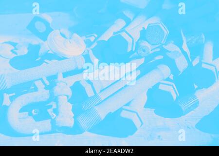 Pile of old rusty nuts and bolts close-up soft blue hue as background industrial image Stock Photo