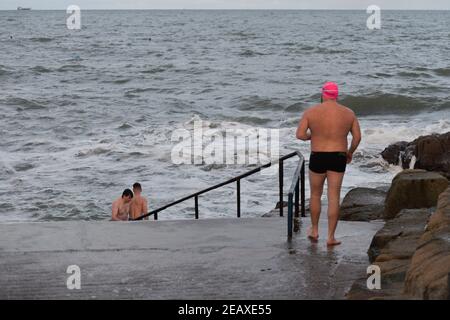 Dublin, Ireland. 10th Feb, 2021. Swimmers take a dip in the sea at the Forty Foot Promontory in Sandycove Beach area in Dublin.Ireland has so far confirmed 205,000 Coronavirus cases with 23,364 recovered and 3,752 deaths. Credit: SOPA Images Limited/Alamy Live News Stock Photo