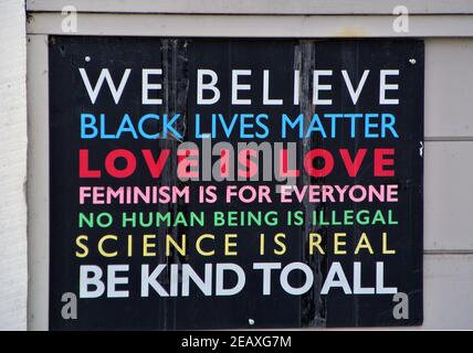 sign on building during black lives matter protestshow concern t for feminism , illegal imigratiion science beings real, love is love a all Stock Photo