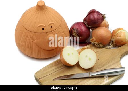 red an withe onions in a terracotta pot to be stored under dry conditions isolated on white background Stock Photo