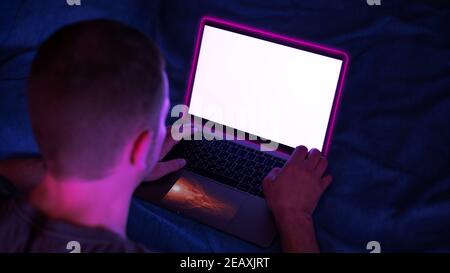 the guy at the laptop at work, led neon lights, laptop computer, white screen Stock Photo