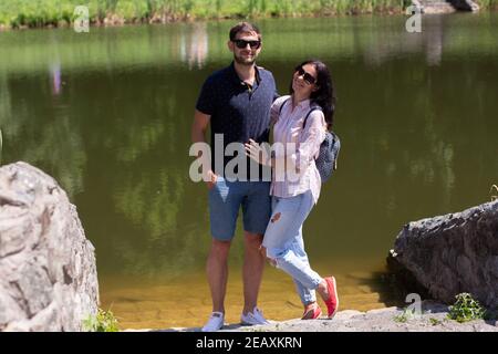 guy with a girl near the lake wearing glasses in summer Stock Photo