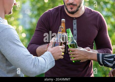Group of  friends enjoying drinking alcohol on their weekend outdoors in the garden Stock Photo