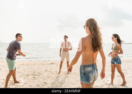 Attractive young group of friends enjoying playing beach game together in summer Stock Photo