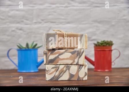 Colorful handmade soap. Succulents in watering cans in the background. Stock Photo