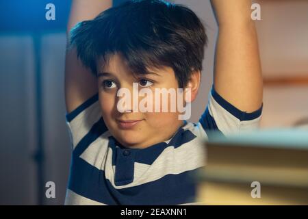 boy doing gymnastic stretching between classes in the room Stock Photo