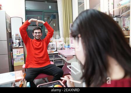 Wuhan, China's Hubei Province. 6th Feb, 2021. Li Jing (front), an illustrator in Wuhan, creates illustrations with Israeli blogger and entrepreneur Raz Galor in Wuhan, central China's Hubei Province, Feb. 6, 2021. Credit: Xiong Qi/Xinhua/Alamy Live News Stock Photo