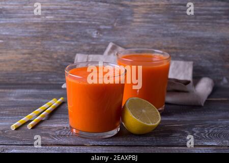 Fresh carrot juice in a glasses on a wooden background, free space Stock Photo