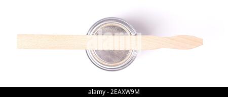 Old stirring stick with a pot of paint, isolated on white Stock Photo