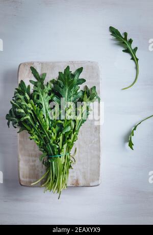 A bunch of fresh rocket leaves on a wooden table Stock Photo