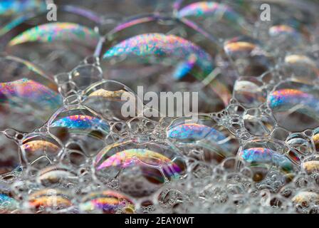 Large soap bubbles with a multicolor rainbow pattern. Floating on water ...