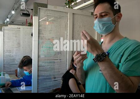 A medical worker administers the Pfizer-BioNTech COVID-19 vaccine to a foreign resident at the Sourasky Medical Centre for foreign nationals on February 09, 2021, in Tel Aviv, Israel. A month and a half after Israel launched its world-leading coronavirus vaccination campaign, Tel Aviv-Yafo Municipality and the Sourasky Medical Center (Ichilov Hospital) started administering Pfizer-BioNTech coronavirus vaccines free of charge to the city's foreign nationals, many of whom are undocumented asylum seekers. Stock Photo