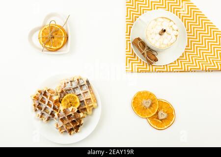 Early breakfast coffee with marshmallows and a stick of cinnamon and Belgian waffles Stock Photo