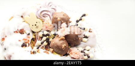 delicious beautiful Easter glazed cake with icing, color decoration, marshmallow, chocolate egg candy, willow, bunny, festive sweet Easter dessert, tr Stock Photo