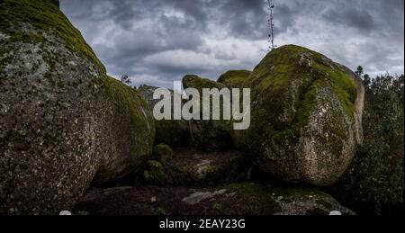 Place with a lot of big stones covered in moss in a stormy environment and grey day Stock Photo