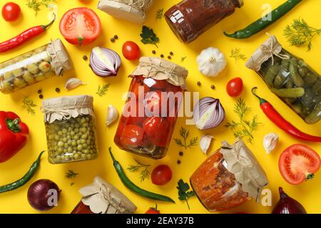 Flat lay with different canned food and ingredients on yellow background Stock Photo