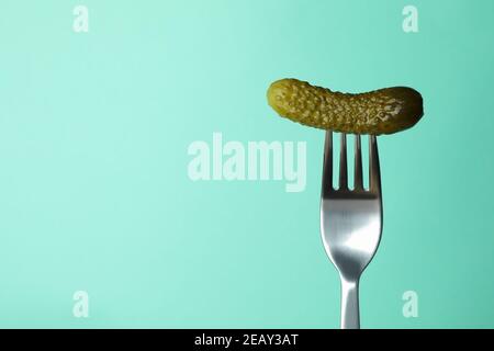 Fork with pickled cucumber on mint background Stock Photo