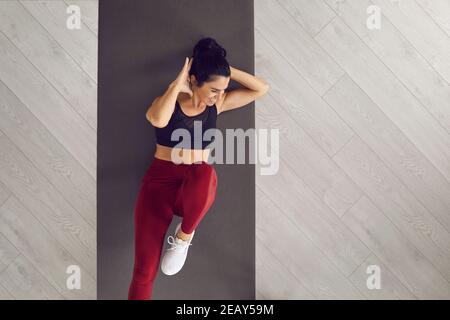 Top view of sporty active woman doing cross training bicycle crunches trains leg muscles and abs. Stock Photo