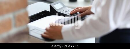 Woman in office prints documents on printer Stock Photo