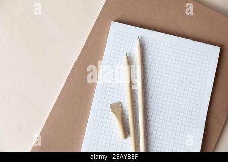 Reusable eco-friendly craft paper pen and pencil on notebook. Writing ballpoint pen, environmental protection, natural materials, recycling concept Stock Photo
