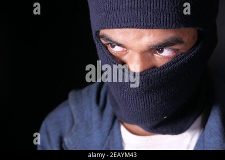 Thief in a mask on black background close up, Stock Photo
