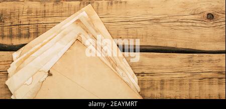 Sheets of old vintage paper on a wooden table. Copy space Stock Photo