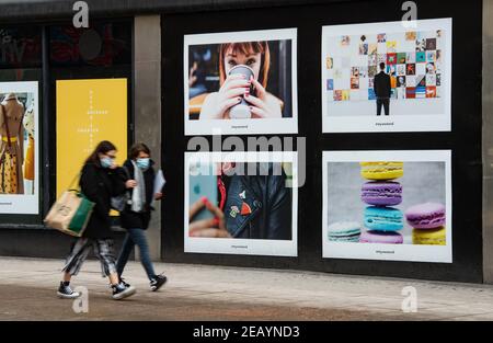 Shoppers pass a boarded up shop on Oxford Street Stock Photo