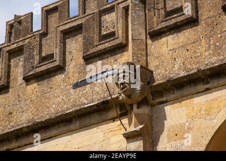 Gargoyle grotesque detail (Mat Hatter) on St Peter's Church in the market town of Winchcombe, Gloucestershire Stock Photo