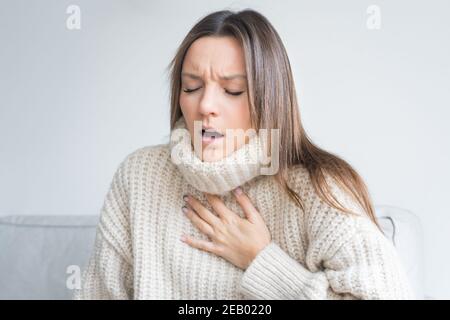 Woman having breath difficulties. Shortness of breath. Coronavirus cough breathing problem Stock Photo