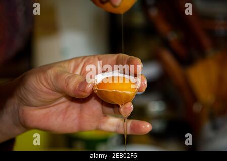 Egg and egg shell in a human hand, cooking with eggs in the kitchen Stock Photo
