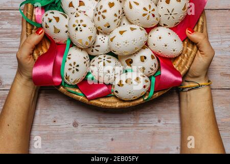 Happy Easter. Woman Hands holding basket with hand made decorated Easter eggs.Spring decoration background. Festive tradition for Eastern Europe Stock Photo